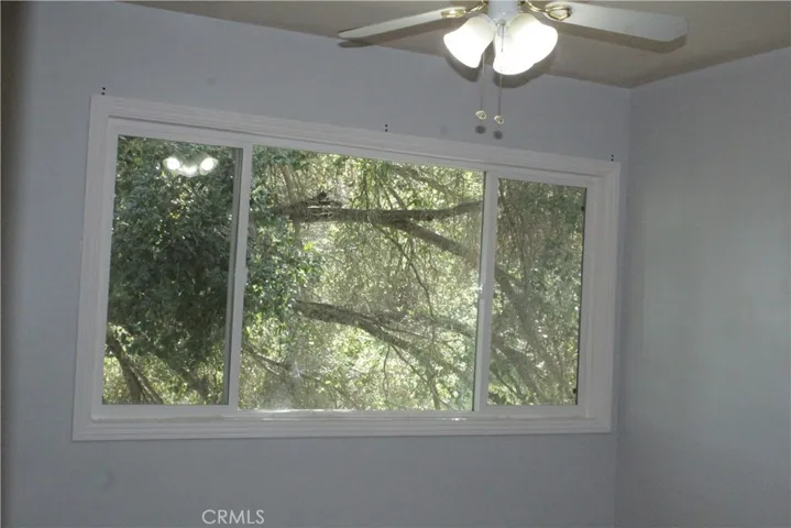 Middle bedroom with ceiling fan and big window
