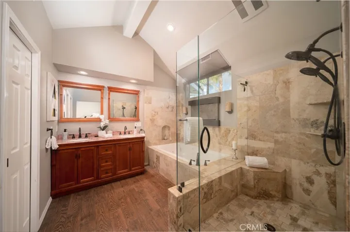 Master bathroom with double shower heads, a stone waterfall above the soaking tub and walk in closet.