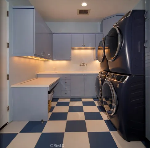 Laundry room capable of handling lots of laundry with matching pairs of washers & dryers.