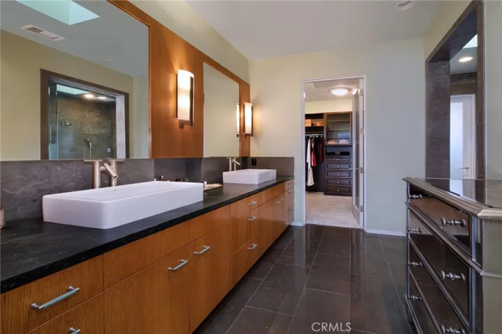 Spacious master bathroom with dual sinks and walk-in​​‌​​​​‌​​‌‌​​‌​​​‌‌​​​‌​​‌‌​​‌‌​​‌‌​​​​ closet.