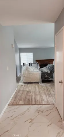 The entry way welcomes you with marble walkway and bright laminated wood with a view of the living room.