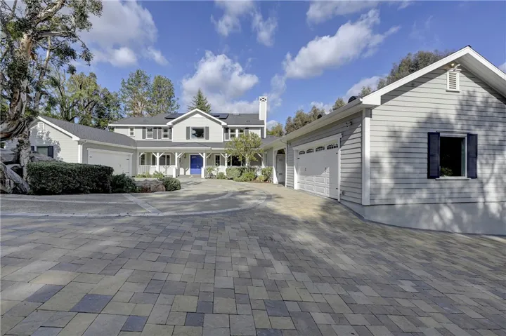 On the right side of this photo is an extra large 2 car garage with EV chargers and a carport for a 5th vehicle which also has an EV charger.