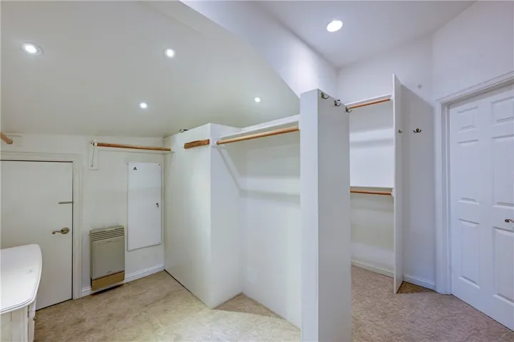 Large walk in closet with access from primary suite and bath. Note the door on the left is to the attic and has a path to the garage for an 'escape'.