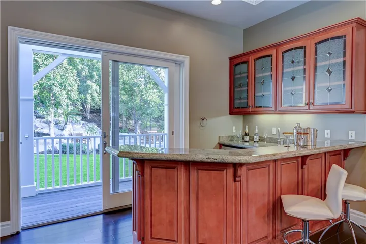Wet bar with mini fridge and a slider to the deck and backyard.