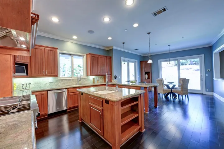 Grand kitchen and eating nook with sliders to the side and backyards.