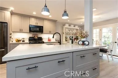 Center island in kitchen with Quartz counters, pendant lighting