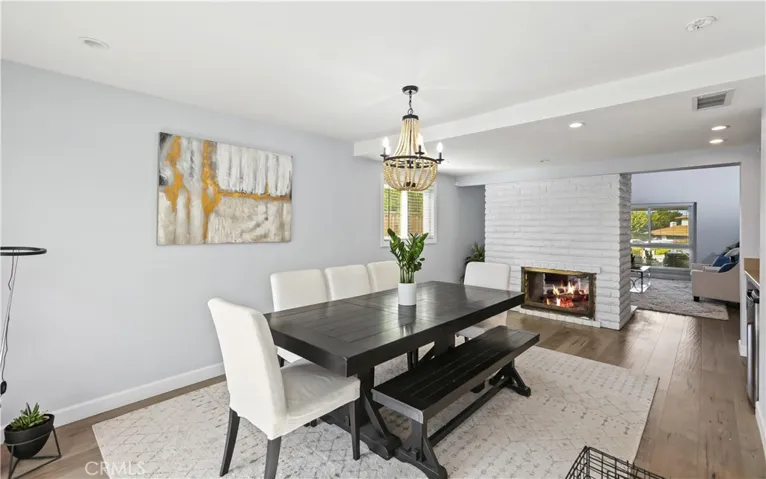 Dining room looks out to beautiful yard and cozy fireplace.