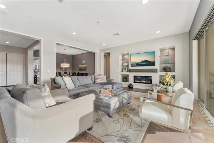 Beautiful living room with gas fireplace, wood floors, recessed lights, 10' foot high ceilings.