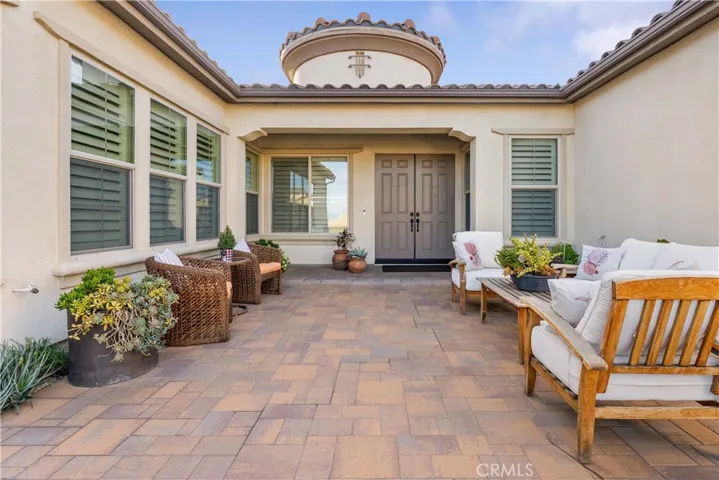 Beautiful courtyard to double door entry with pavers.