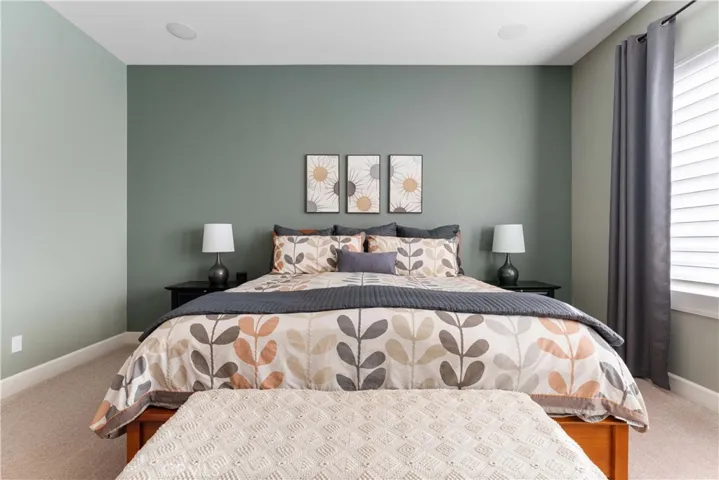 Spacious primary bedroom with ceiling fan and window view of the backyard.