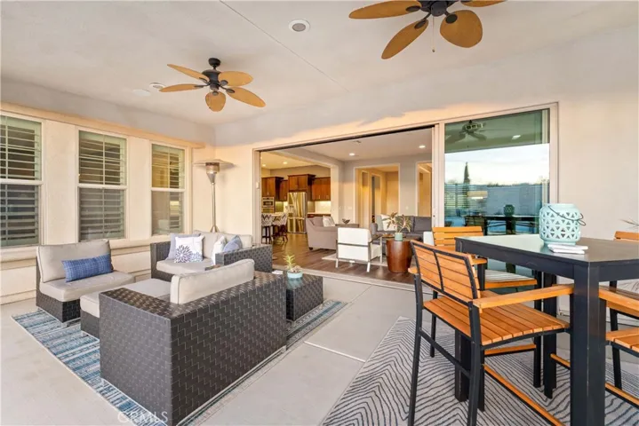 Spacious covered patio with California sliding doors and ceiling fans and recess. lighting.
