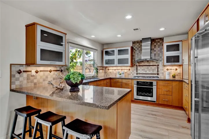 Upgraded Chef's Kitchen that Includes Caesarstone Quartz Countertops, Breakfast Bar, Stainless GE Monogram Appliances (5-Burner Gas Cooktop, Electric Oven, Microwave, Dishwasher), and Custom Soft-Closing Cabinetry with Pull-Outs, Hidden Recycle Trash, Lazy Susan, and Other Specialty Spaces