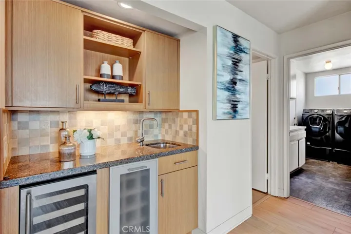 Wet Bar w/Cold & Controlled-Temp Wine Storage, Granite Counter, and sink. Powder Room and Inside Laundry Room