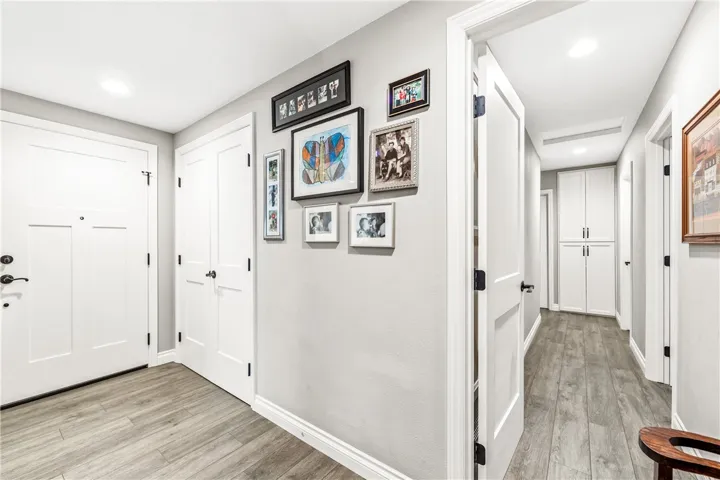 Looking back at the front door with large custom storage closet and hallway to the bedrooms.
