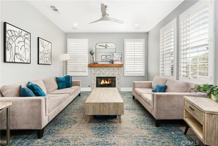 Family room has new flooring, custom fireplace surround, shutters, new paint, and recessed lighting.