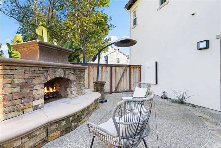 Entertainers backyard with large fireplace, custom outdoor kitchen with grill/smoker, refrigerator, outdoor tv.