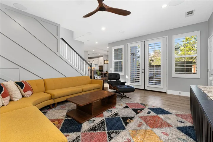 Family room has surround sound, ceiling fan, French doors to outdoor veranda, recessed lighting, and new flooring.