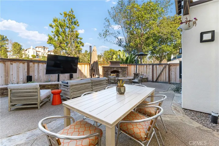 Entertainers backyard with large fireplace, custom outdoor kitchen with grill/smoker, refrigerator, outdoor tv.