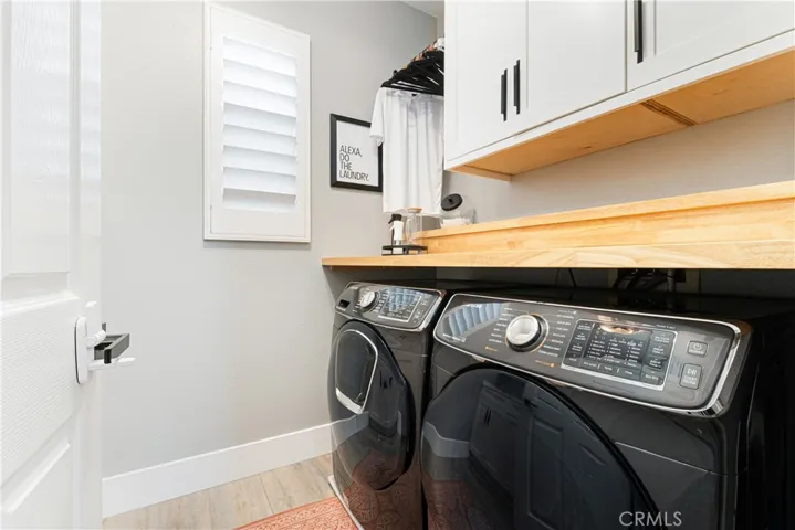 Laundry room has additional cabinets and custom butcher block counters.