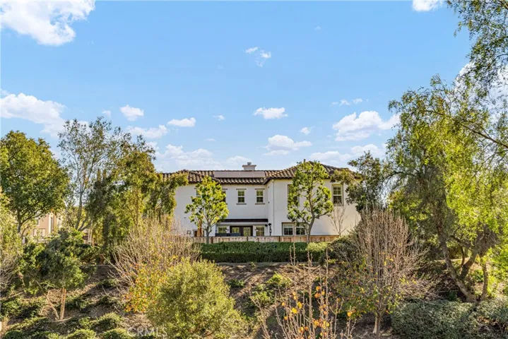 The house on the hill surrounded by lush greenery and views.