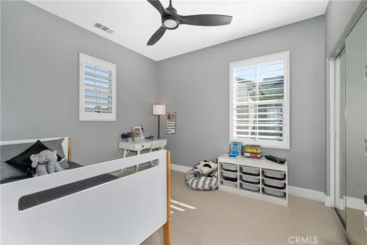 Additional bedrooms have custom shutters, ceiling fans, and fresh paint.