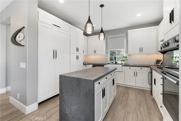 Designer kitchen with high end appliances including Thermamdor refrigerator, custom counter tops, custom backsplash, new cabinet doors, new flooring, and wine refrigerator.