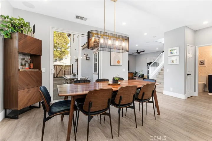 Dining enclave is modern with custom chandelier, new flooring, and sliding door to outdoor veranda.