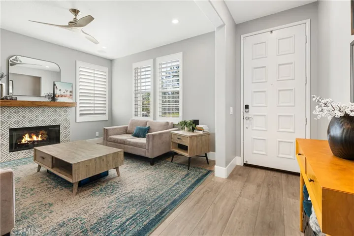 Family room has new flooring, custom fireplace surround, shutters, new paint, and recessed lighting.