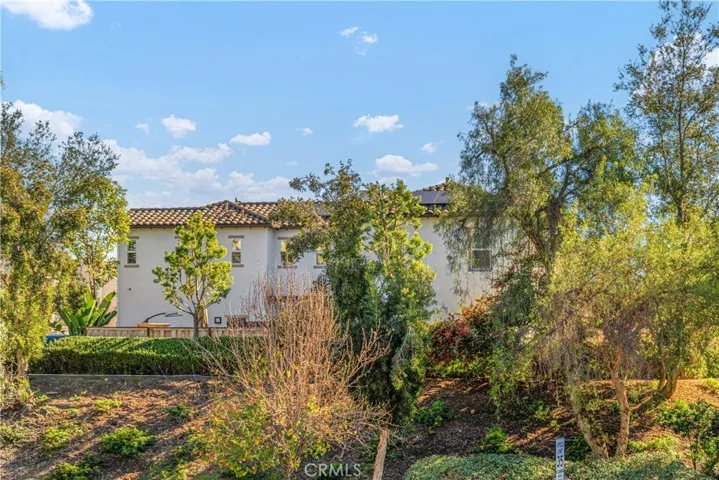 The house on the hill surrounded by lush greenery and views.