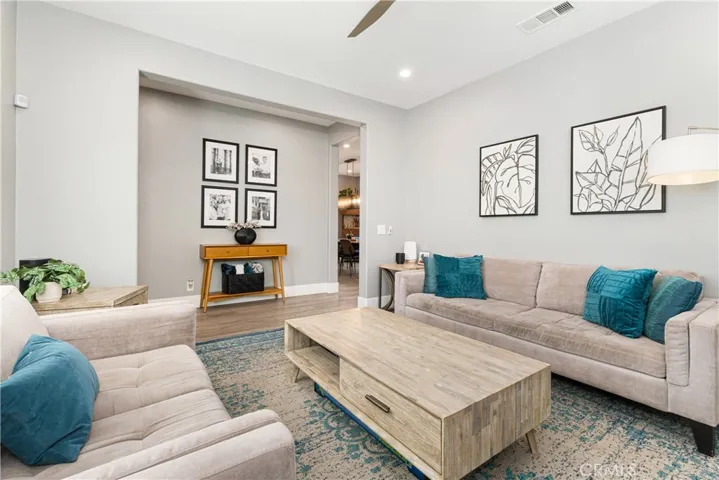 Family room has new flooring, custom fireplace surround, shutters, new paint, and recessed lighting.