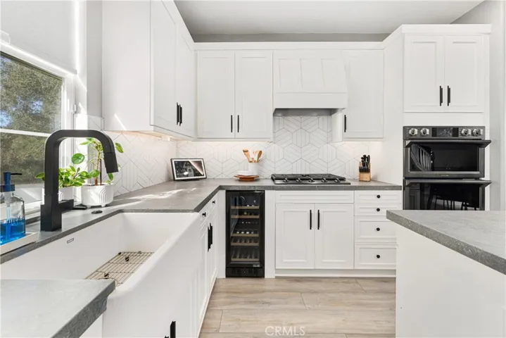 Designer kitchen with high end appliances including Thermamdor refrigerator, custom counter tops, custom backsplash, new cabinet doors, new flooring, and wine refrigerator.