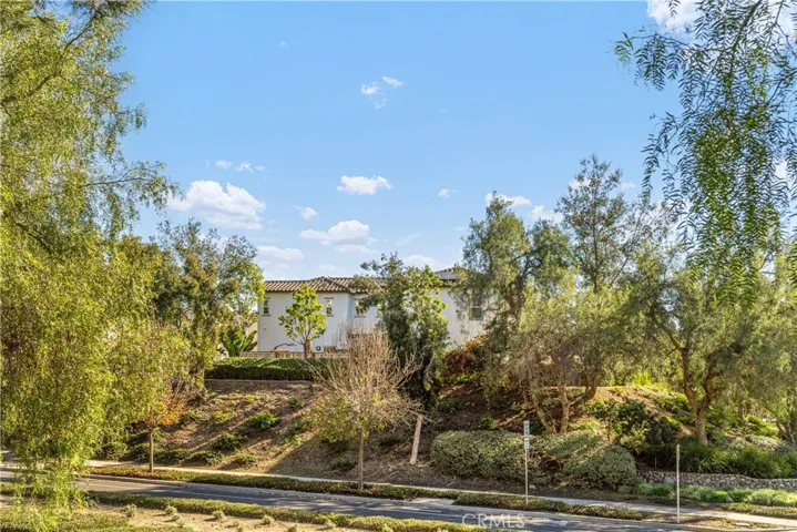 The house on the hill surrounded by lush greenery and views.