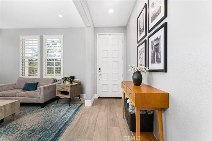 Family room has new flooring, custom fireplace surround, shutters, new paint, and recessed lighting.