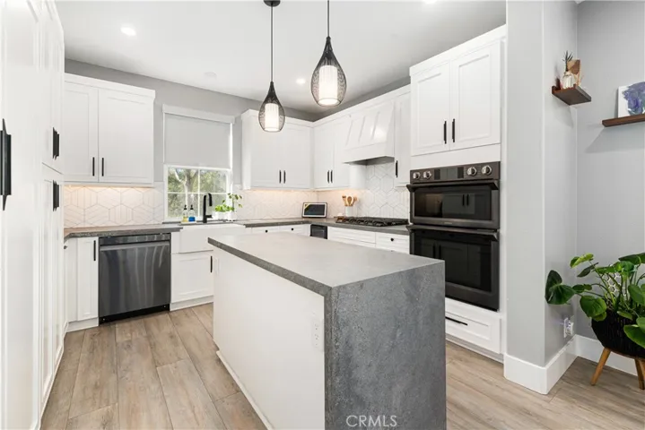 Designer kitchen with high end appliances including Thermamdor refrigerator, custom counter tops, custom backsplash, new cabinet doors, new flooring, and wine refrigerator.