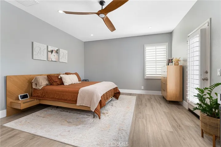 Owner's suite has custom barn door, Juliet balcony, new flooring, ceiling fan, custom shutters.