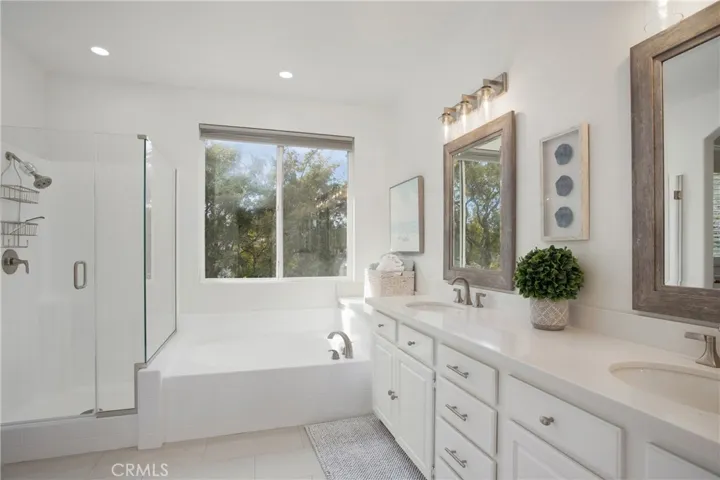 Primary bathroom with quartz counters, dual sinks, soaking tub with trees view!