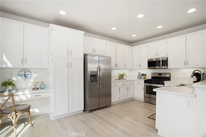 Beautiful big kitchen is light with quartz counters and stainless appliances