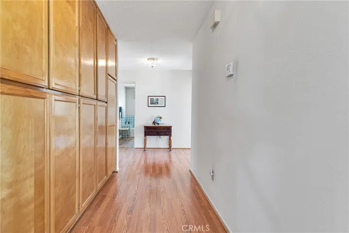 Extra wide hallway with more cabinet & closet storage on laminate wood flooring.