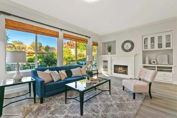 Spacious family room lined with sunlit windows, renovated luxury wood-like flooring and quartz clad finishings