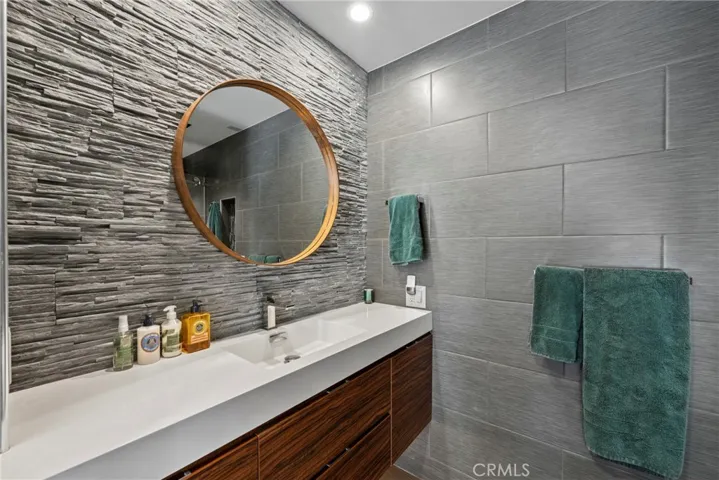 Tile Wall Backsplash, Floating Duravit Vanity, Large Round Mirror, and Recessed Ligthing!