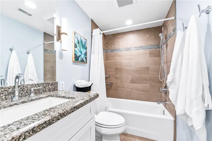 Remodeled bathroom featuring freshly tiled tub surround