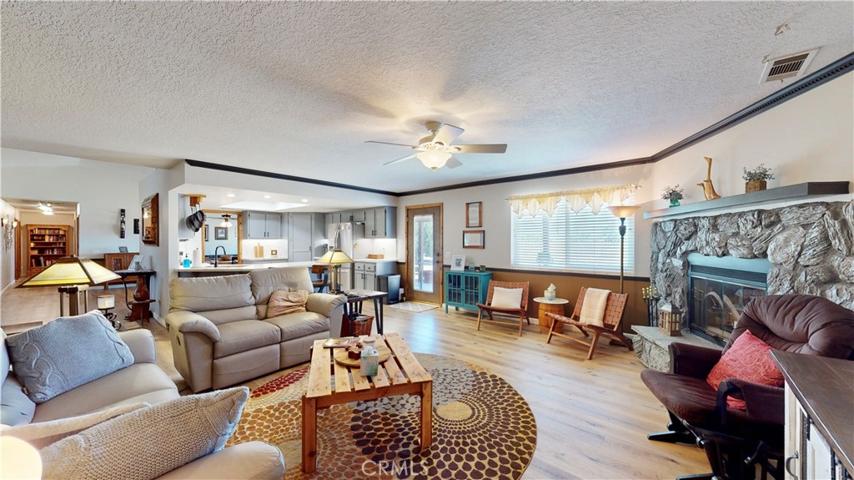 huge family room with wood burning fireplace, raised hearth and hand crafted custom wooden manted.