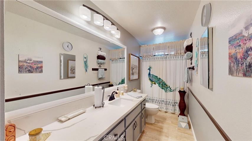hall bathroom upgraded quartz countertops, tiled flooring, new lighting, faucets plumbing, wood framed mirror.