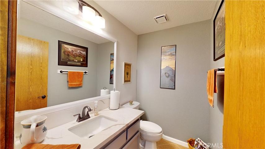 remodeled 1/2 bath adjacent to office/bonus room. quartz countertops, new adult-sized toilets, tile flooring and Wood framed mirror
