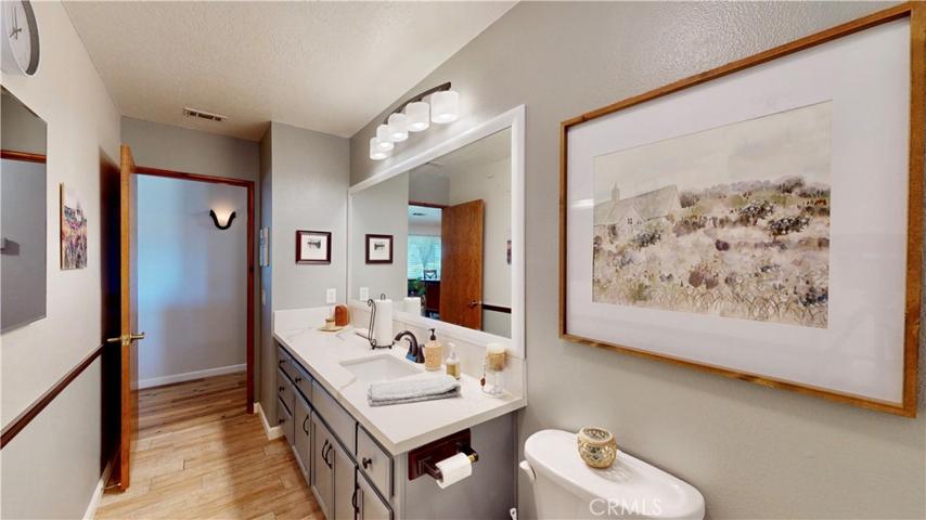 hall bathroom upgraded quartz countertops, tiled flooring, new lighting, faucets plumbing, wood framed mirror.