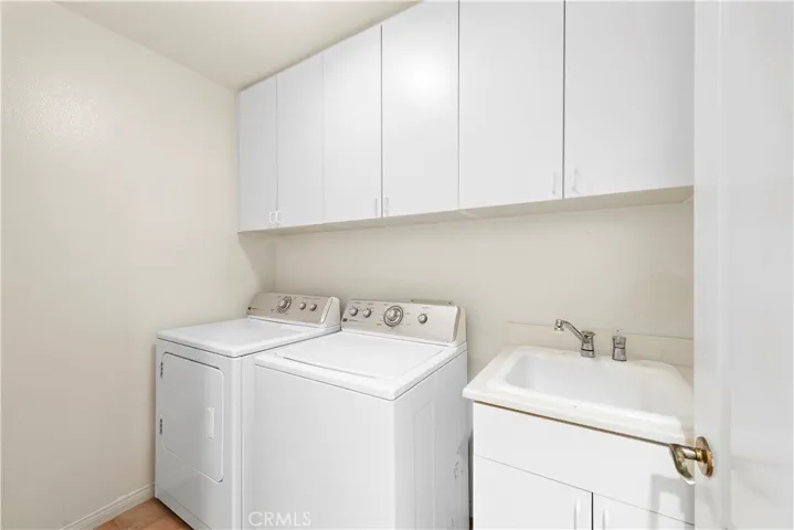 Main level laundry room with utility sink and storage