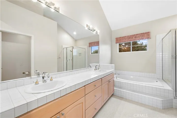 Primary Bath has Dual vanity and large mirrored wal wth maple cabinetry