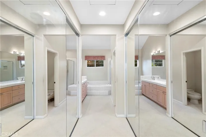 The primary bedroom has tall mirrored wardrobe doors that open to ample closet space.