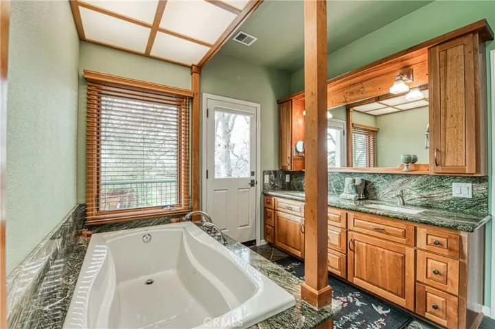 Main bathroom has custom built Cherry cabonets with Italian Rainforest marble lining the sink and tub.
