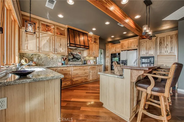 Kitchen has granite counter tops with custom Hickory built-in cabinets.